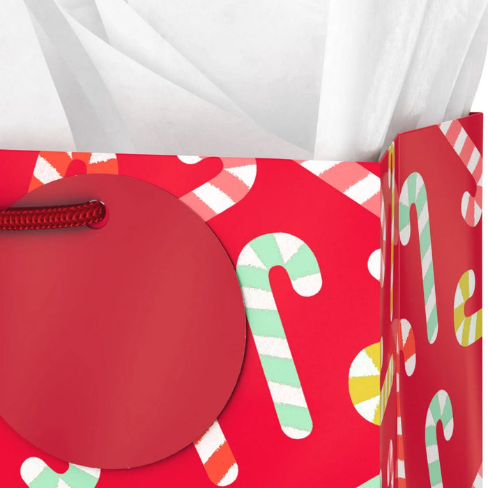9.6-inch medium red Christmas gift bag featuring candy cane designs with tissue paper.