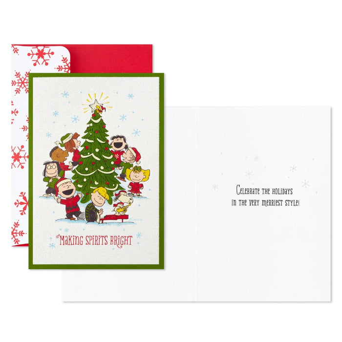 Hallmark Peanuts Gang Christmas cards featuring Snoopy and friends caroling around a decorated Christmas tree, pack of 16.