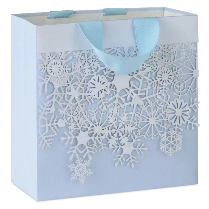 Hallmark 10.4-inch large Christmas gift bag featuring white snowflakes on a light blue background, complete with tissue paper, perfect for wrapping holiday presents and festive gifts for family and friends.