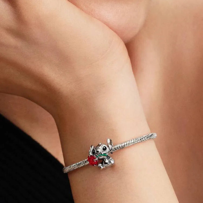 Bracelet with a panda charm on a wrist against a neutral background