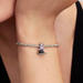 Bracelet with a Ursula charm on a wrist against a neutral background