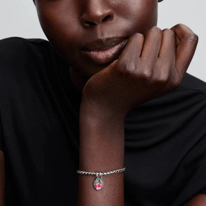 Silver bracelet with a bird-shaped charm on the wrist of a women