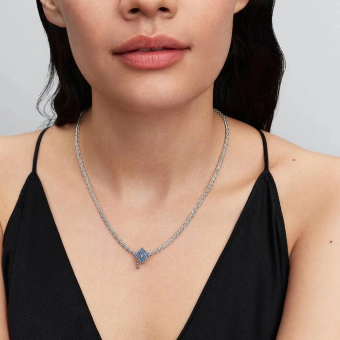 Silver necklace with a graduation cap charm on a women