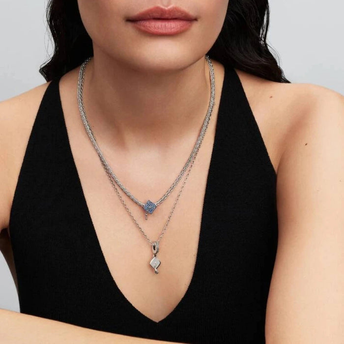 Silver necklace with a graduation cap charm on a women