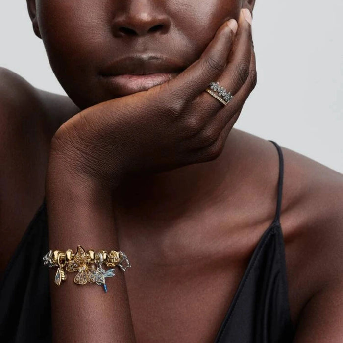 Gold bracelet with a cicada-shaped charm on the wrist of a women