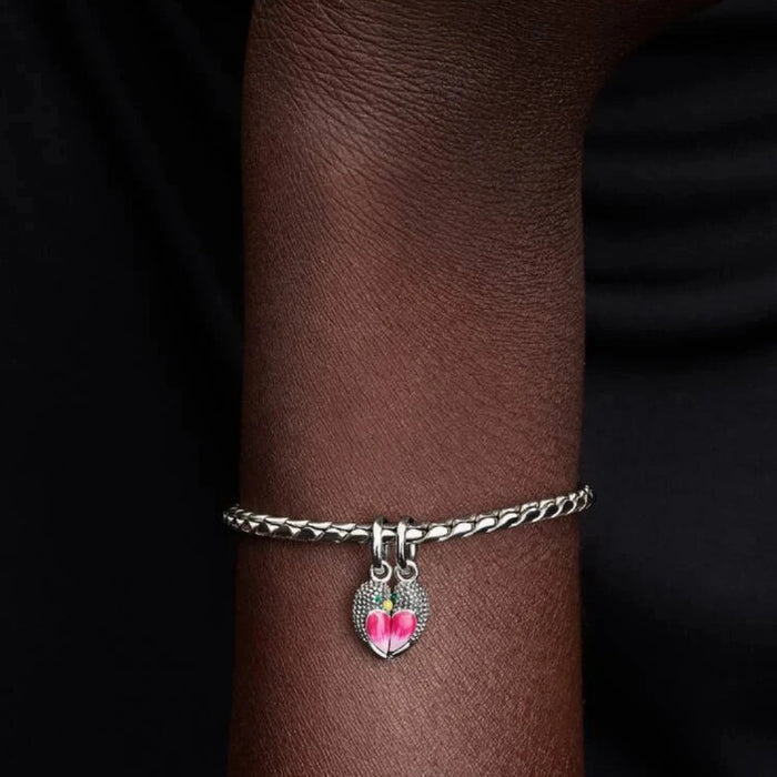 Silver bracelet with a bird-shaped charm on the wrist of a women