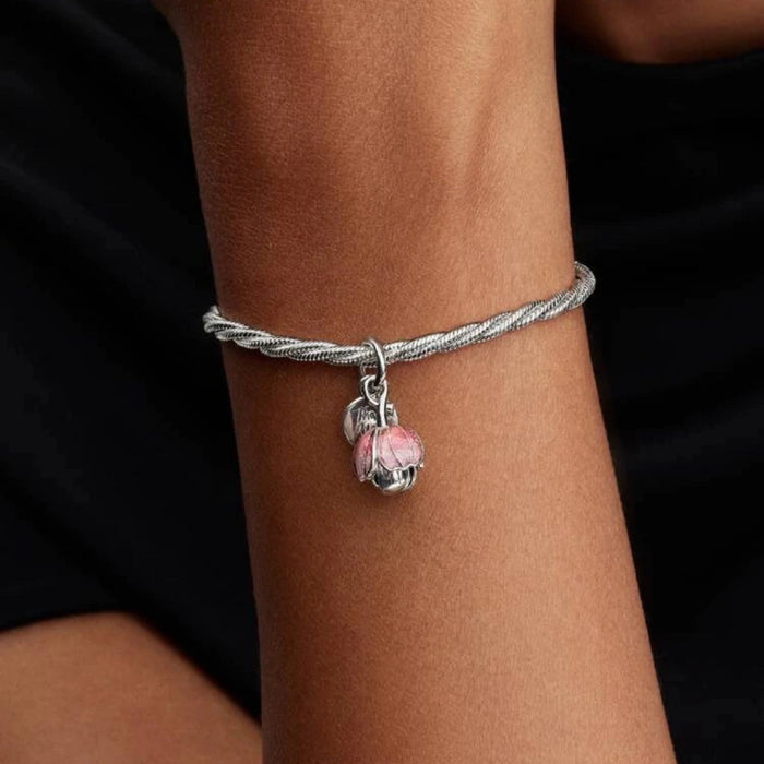 Silver bracelet with a flower-shaped charm on the wrist