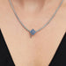 Silver necklace with a graduation cap charm on a women