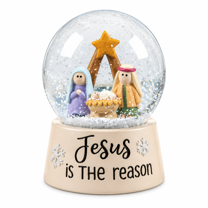 Snow globe with Mary, Joseph, and baby Jesus beneath a gold star, on a cream base reading “Jesus is the reason.”