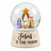 Snow globe with Mary, Joseph, and baby Jesus beneath a gold star, on a cream base reading “Jesus is the reason.”