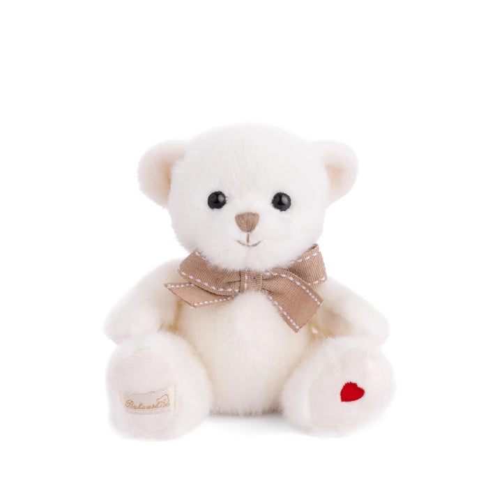 A white teddy bear wearing a brown bow, sitting upright against a soft background.