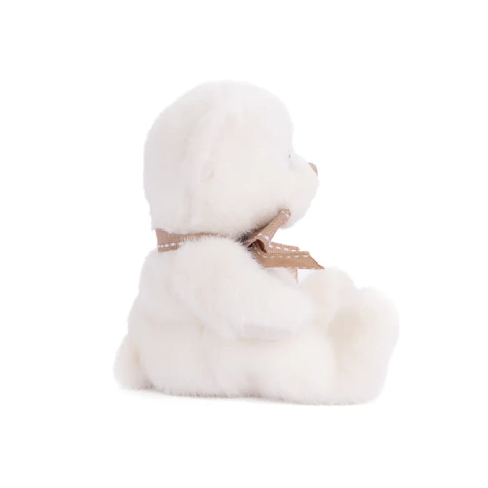 A fluffy white teddy bear featuring a brown bow, resting peacefully, inviting hugs and affection.