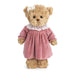 A teddy bear wearing a pink dress, sitting upright with a friendly expression.