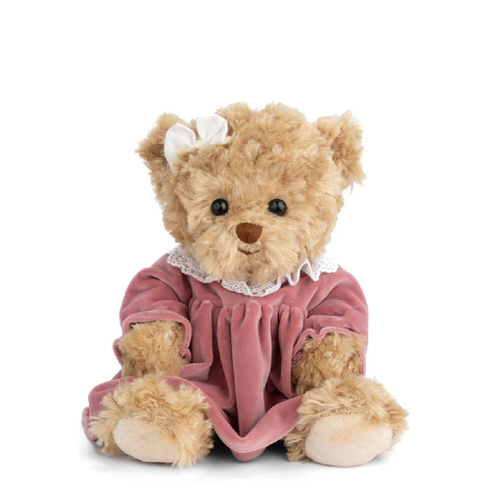 A cute teddy bear dressed in a pink dress, showcasing its soft fur and cheerful demeanor.