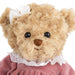A teddy bear adorned in a pink dress, exuding charm and warmth with its inviting smile.