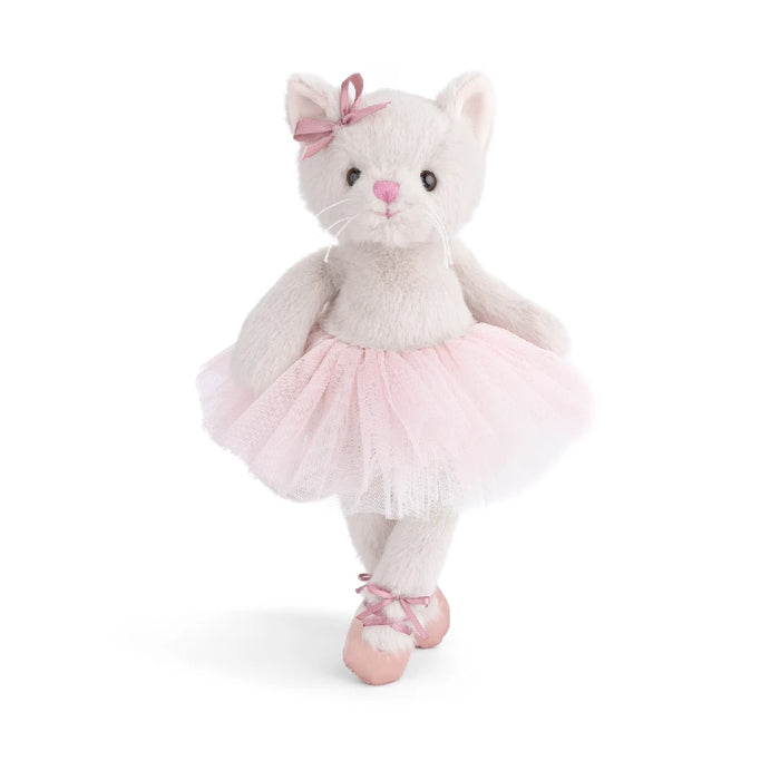  A stuffed cat wearing a pink tutu skirt, sitting upright with a playful expression.