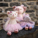 A stuffed feline in a vibrant tutu skirt, positioned cutely with a friendly demeanor.