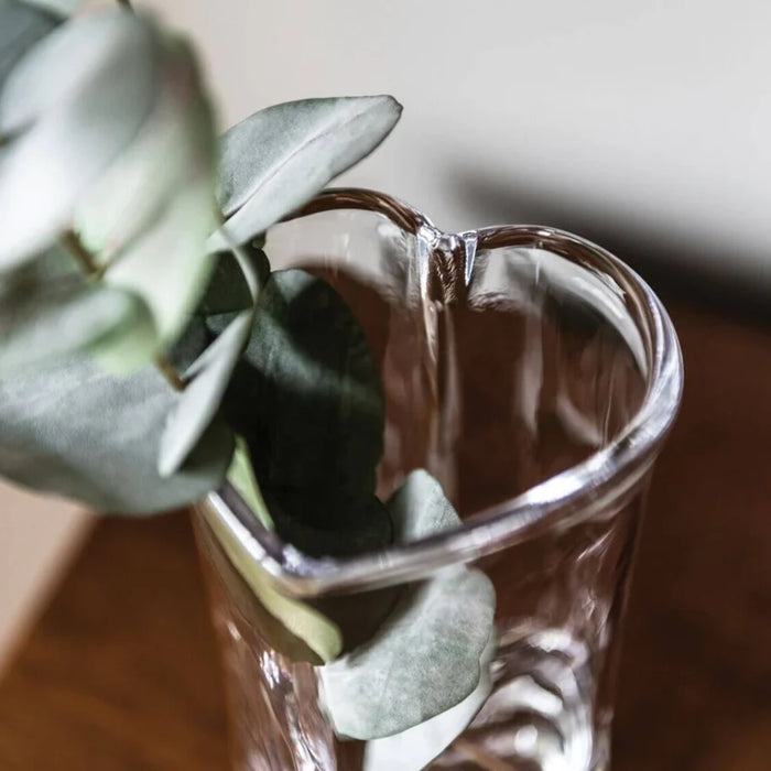 A simple vase filled with water, featuring a thriving plant growing within.