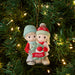 Christmas ornament of two children holding a wreath with '2025' on a decorated tree.