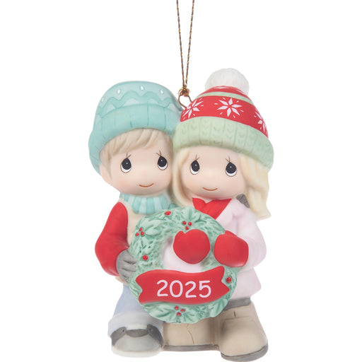 Christmas ornament of two children holding a wreath with '2025' on a white background