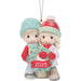 Christmas ornament of two children holding a wreath with '2025' on a white background
