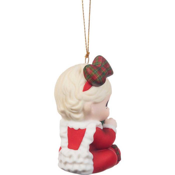 Christmas ornament of a child in a stocking with a plaid bow on a white background