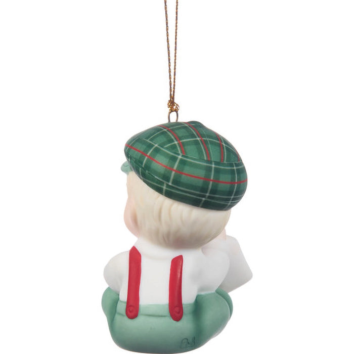 Decorative ornament of a person wearing a green tartan hat and red suspenders on a white background.