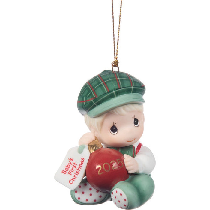 Christmas ornament of a baby holding a red ball with 'Baby's First Christmas 2023' tag, wearing a green cap and outfit.