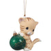 Cat-shaped ornament holding a green ball with '2025' on a white background