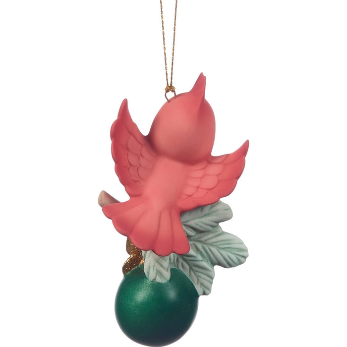 Decorative ornament with a red bird on a green ball against a white background