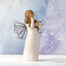 Angel figurine with a heart on a textured light blue background