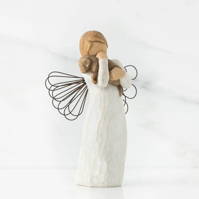 Angel figurine holding a child on a white background