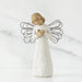 Angel figurine with outstretched wings holding a baby on a marble background