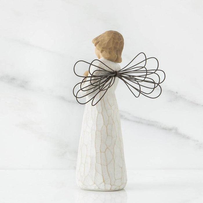 Ceramic angel figurine with wire wings on a white background