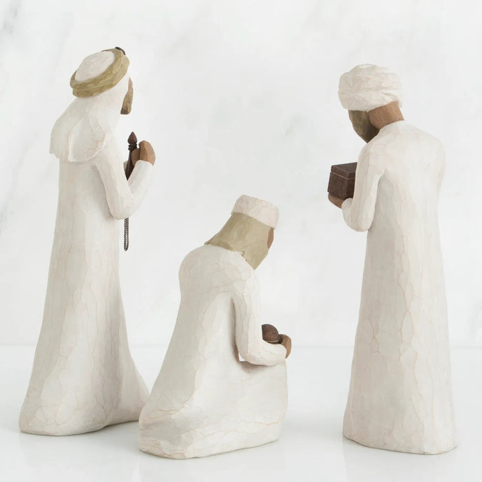 Three white ceramic figures with different poses on a white background