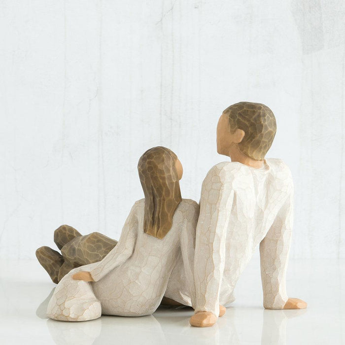 figure of a Father and a child sitting together on a white background