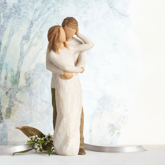 Statue of a couple embracing with a decorative background