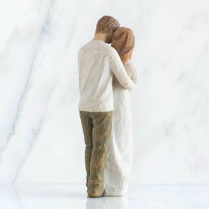 Statue of a couple embracing on a white background
