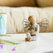 Decorative figurine of an angel holding a dog on a light surface with a blurred background