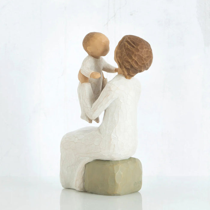 Willow Tree Grandmother figurine holding a baby back and side view on a white background. 