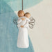 Decorative angel figurine ornament  holding another against a light blue and beige background