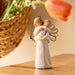 Decorative figurine ornament  of two people embracing on a wooden surface with flowers in the background