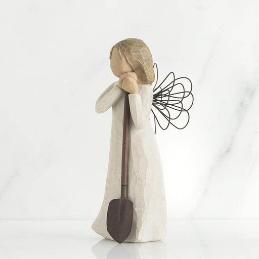 Angel figurine with a shovel on a white background