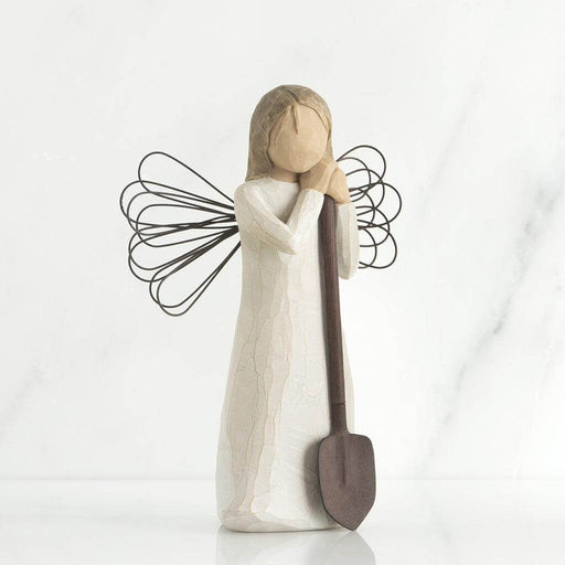 Decorative angel figurine with a shovel on a white background