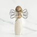 Angel figurine with outstretched wings holding a heart on a white background