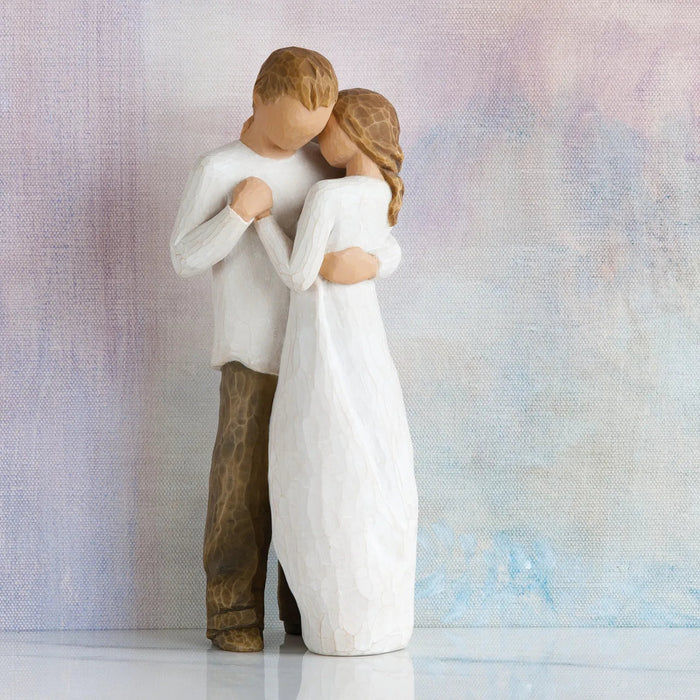 Statue of a couple embracing against a textured light background