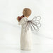 Decorative angel figurine holding two apples on a white background