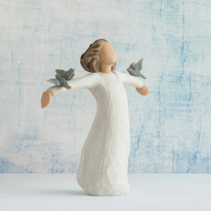Angel figurine with outstretched arms against a textured blue and white background