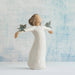 Angel figurine with outstretched arms against a textured blue and white background