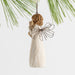 Angel ornament holding a butterfly against a white background with greenery.